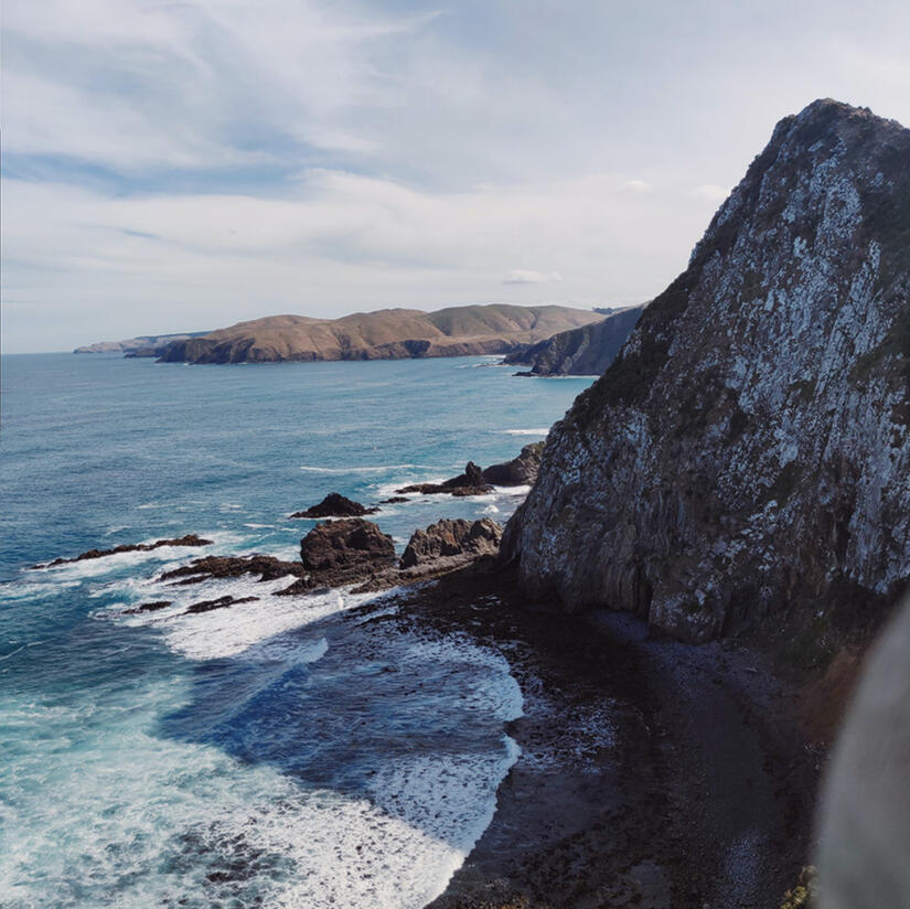 a blue sea meets a cliff in different shades of blue, by tayylin.com